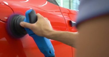 Araba merkezinde (garajda), profesyoneller yeni bir spor araba Lehçe. Lüks araba parlatma. Kavramı: yarış, spor araba, yeni, yavaş hareket, NASCAR, kırmızı, krom kaplama.