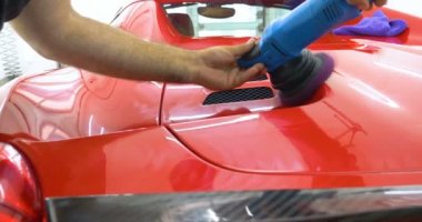 Araba merkezinde (garajda), profesyoneller yeni bir spor araba Lehçe. Lüks araba parlatma. Kavramı: yarış, spor araba, yeni, yavaş hareket, NASCAR, kırmızı, krom kaplama.
