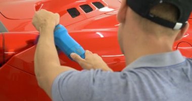 Araba merkezinde (garajda), profesyoneller yeni bir spor araba Lehçe. Lüks araba parlatma. Kavramı: yarış, spor araba, yeni, yavaş hareket, NASCAR, kırmızı, krom kaplama.