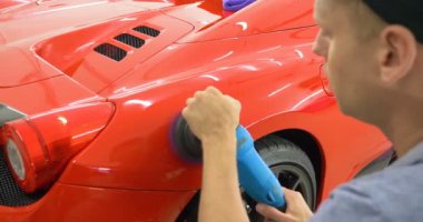 Araba merkezinde (garajda), profesyoneller yeni bir spor araba Lehçe. Lüks araba parlatma. Kavramı: yarış, spor araba, yeni, yavaş hareket, NASCAR, kırmızı, krom kaplama.