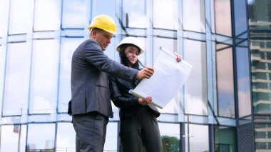 Mimarlar takımı ve inşaat sahasındaki belgeleri ve iş akışını kontrol eden bir grup mühendis. Mimari plan için işyerinde mühendis teftişi. Kadın, Erkek, Süit, İş Konsepti.