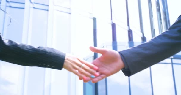 ビジネスウーマンとビジネスマンの握手を閉じるビジネスパートナーシップ コンセプト 高層ビル ディール ビジネスビル 建築家 ライフスタイル — ストック動画