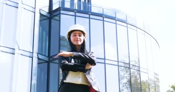 身着西装的女商人 双臂交叉 看着相机 面带微笑 摩天大楼背景 新业务 — 图库视频影像