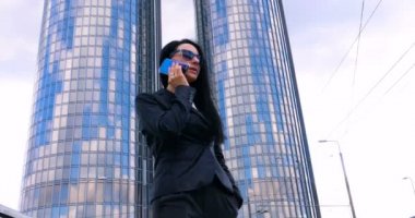 İş mimarisi geçmişinden telefonla arayan mutlu bir iş kadını. Gökdelen, İş Kızı, Mimar, Yaşam Tarzı.