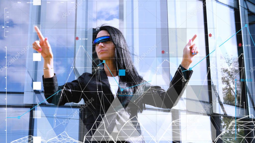 Virtual holographic interface and young woman wearing glasses, Successful businesswoman wearing virtual reality glasses while working with virtual screen. Concept of: Future, Skyscraper, Infographic.