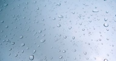 Araba cam arka plan üzerinde yağmur damla. Yağmur damlaları ile araba penceresinden yol manzarası, yağmurda sürüş. Yağmur gününde soyut trafik. Araba koltuğundan bak. Konsept: Sürücü, Hızlı, Yalnız, Araba, Yakın Çekim.