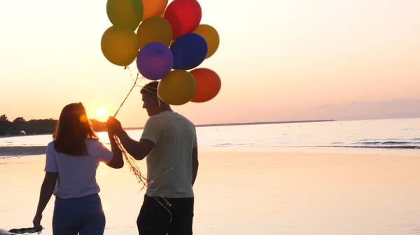 Belo Pôr Sol Mar Jovem Casal Caminha Com Balões Suas — Fotografia de Stock