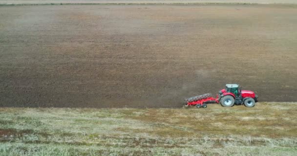 トラクターと収穫フィールドの空中ビュードローンは乾いた草を刈る 収穫トップビューの後に干し草と秋の黄色のフィールド ハーヴス畑でティン ストックアップ — ストック動画