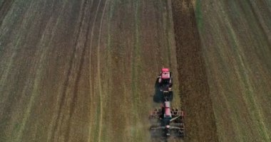 Hasat alanının hava görüntülü dronu traktörle kuru çim biçiyor. Sonbahar sarı tarlası ve hasat sonrası saman yığını. Harves. Tarlalarda karıncalanma. Stok yap.
