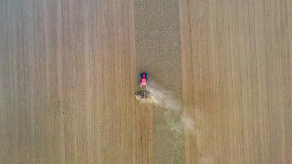 Aerial view drone of harvest field with tractor mows dry grass. Autumn yellow field with a haystack after harvest top view. Harves. Ting in the fields. Stock up