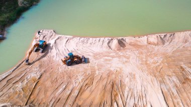 Ariel Excavator 'un bulutlu ama güneşli bir günde bir inşaat sahasına park edilmiş görüntüsü..