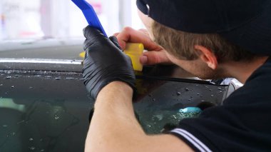 Ön far ve kaputta Ppf montaj işlemine yakın. Ppf, boyayı çizilmelerden ve taş yongalarından koruyan bir Boya Koruma Filmidir. Konsept: Koruma, Koruma, Araba, Yeni, İş.