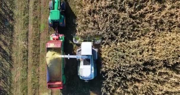 Vue aérienne de la moissonneuse chargeant du maïs sur des remorques. Vue aérienne d'une moissonneuse moderne chargeant du maïs sur des semi-remorques. Concept de : Tracteur, Récolte, Drone, Eco.