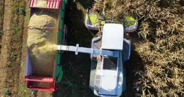 Vue aérienne de la moissonneuse chargeant du maïs sur des remorques. Vue aérienne d'une moissonneuse moderne chargeant du maïs sur des semi-remorques. Concept de : Tracteur, Récolte, Drone, Eco.