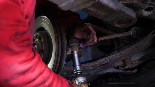 Portrait of a young beautiful car mechanic in a car service, in the background of rubber. Concept: repair of machines, fault diagnosis, repair specialist, technical maintenance and on-board computer.