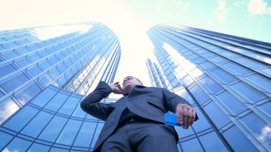 İş adamı internetten alışveriş yapmak için kredi kartı ya da internet kullanıyor. Arkaplanda bankacılık, iş dünyası, iş merkezinin gökdelenleri kavramı.