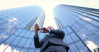 İş adamı internetten alışveriş yapmak için kredi kartı ya da internet kullanıyor. Arkaplanda bankacılık, iş dünyası, iş merkezinin gökdelenleri kavramı.