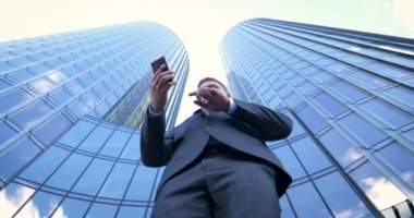 İş adamı internetten alışveriş yapmak için kredi kartı ya da internet kullanıyor. Arkaplanda bankacılık, iş dünyası, iş merkezinin gökdelenleri kavramı.