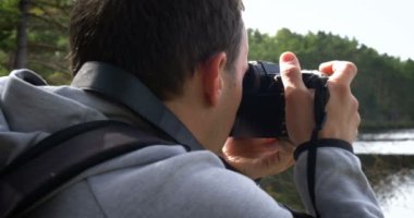 Profesyonel fotoğraf makinesi ve sırt çantalı fotoğrafçı doğanın fotoğraflarını çekiyor..