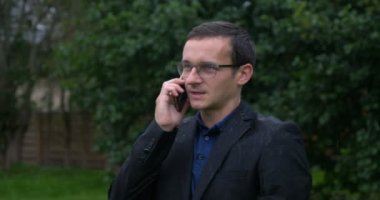 Cep telefonuyla konuşurken kafasında şemsiye tutan bir iş adamını kaybet..