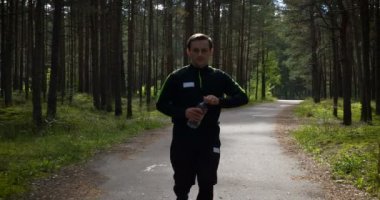 Ormanda koşan genç bir delikanlı. Koşucu doğada egzersiz yapıyor. Sağlıklı yaşam tarzı. eğitim ve idman.