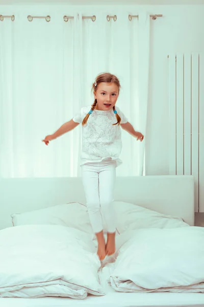 Jumping child girl in bed — Stock Photo, Image
