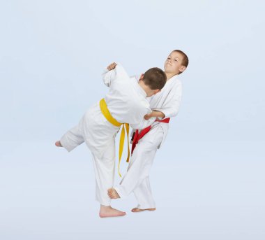 In judogi athletes are training throws on a light background clipart
