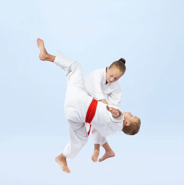 男孩和女孩在 Judogi 是训练投掷 — 图库照片