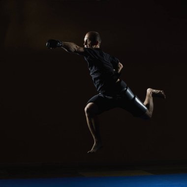 Siyah eldiven içinde güçlü bir atlet bir el ile vurur.