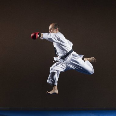 Bir atlet elleri kırmızı bindirmeleri ile bir atlama eliyle bir yumruk trenler