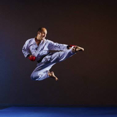 Atlet elleri kırmızı bindirmeleri ile bir atlama içinde bir tekme atıyor