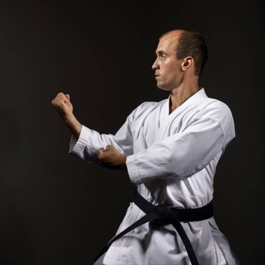 Siyah bir arka plan üzerinde atlet karate resmi çalışmaları gerçekleştirir.