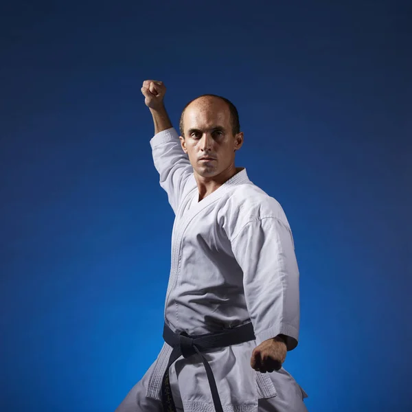 Deportista Realiza Ejercicios Formales Karate Sobre Fondo Azul — Foto de Stock