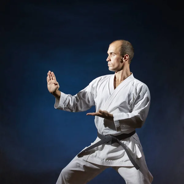 Mörkblå Bakgrund Utför Idrottsman Med Svart Bälte Formell Karate Övningar — Stockfoto