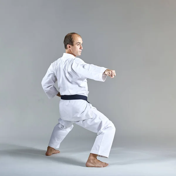 Atleta Entrena Golpe Ejercicio Formal Karate Sobre Fondo Gris — Foto de Stock