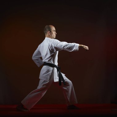 Karanlık bir arka plan üzerinde siyah kuşak ile bir sporcu resmi karate çalışmaları eğitir.