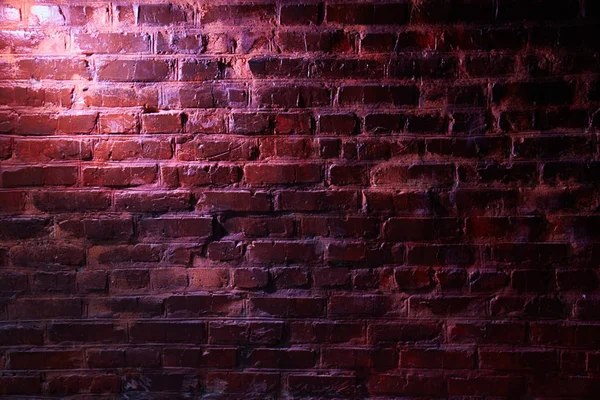 Pink light on a brick wall