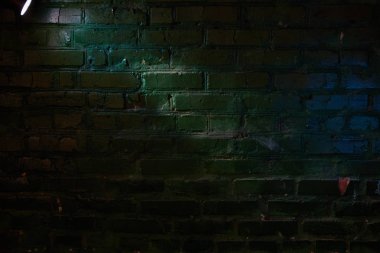 Bir ray ışık ve bir mavi parlak nokta üstünde dokulu tuğla duvar