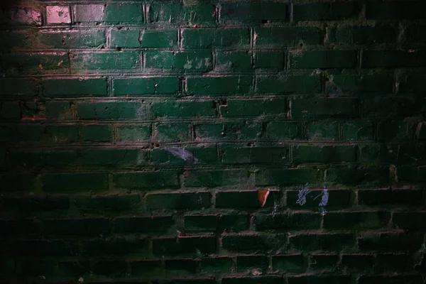Pink glow on the green brick wall