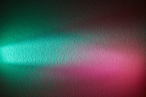 A ray of light and pink volumetric glow against a dark turquoise background