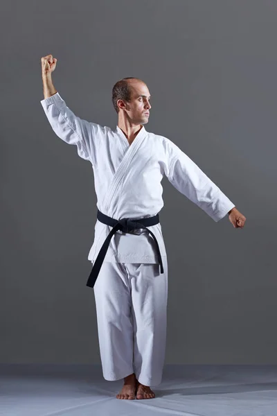 Atleta Adulto Activo Entrena Ejercicios Formales Karate Sobre Fondo Gris — Foto de Stock