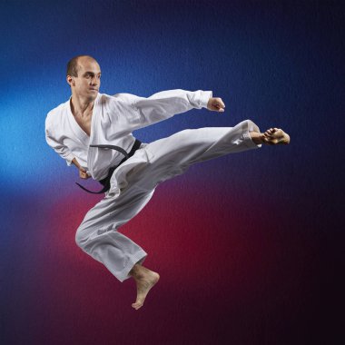 Kırmızı ve mavi arka planda, atlet atlama bir tekme yener