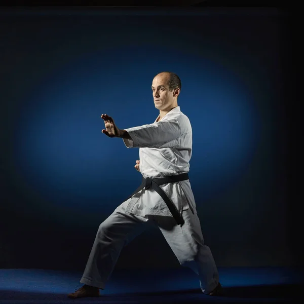Felnőtt Sportoló Végez Hivatalos Karate Gyakorlatok Egy Kék Tatami — Stock Fotó