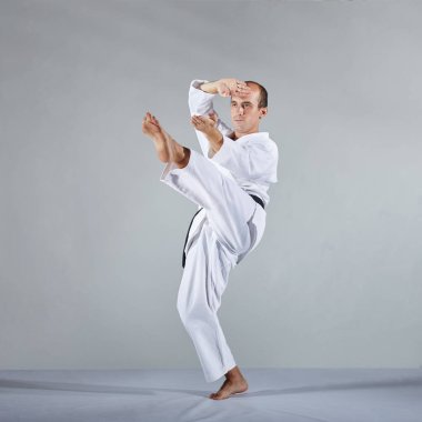 Karategi atlet gri bir arka plan atlet üzerinde resmi karate egzersizleri trenler