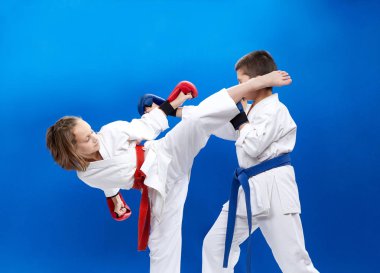 Mavi bir arka planda ellerinde bindirmeleri olan sporcular tekmeleri ve elleri yendiler.