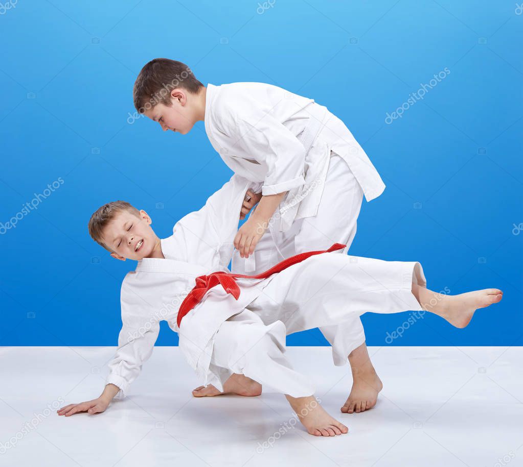 Children with different color belts are doing throws
