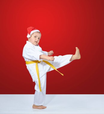 Kırmızı arka planda küçük bir atlet tekme atıyor