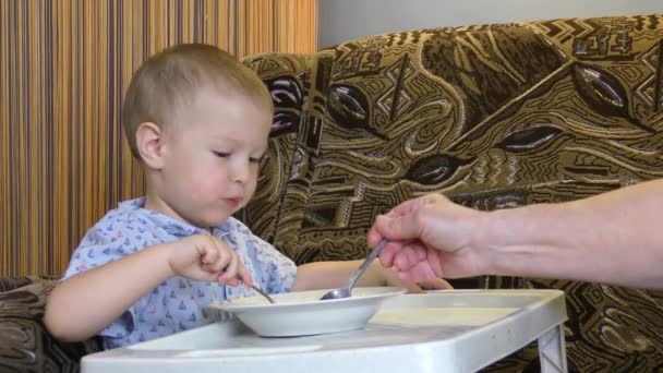 Niño Pequeño Una Pequeña Mesa Blanca Alimentado Con Alimentos — Vídeos de Stock