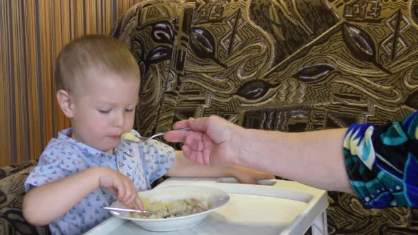 Niño Pequeño Alimentado Con Comida Una Mesa Pequeña — Vídeos de Stock