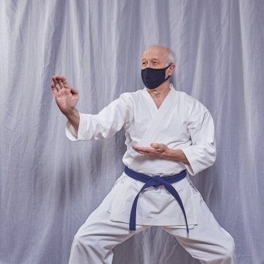 Yaşlı atlet karantinada resmi karate egzersizleri eğitiyor.